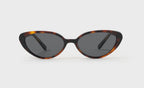 Cat-eye sunglasses with tortoise frame and dark lenses on a white background