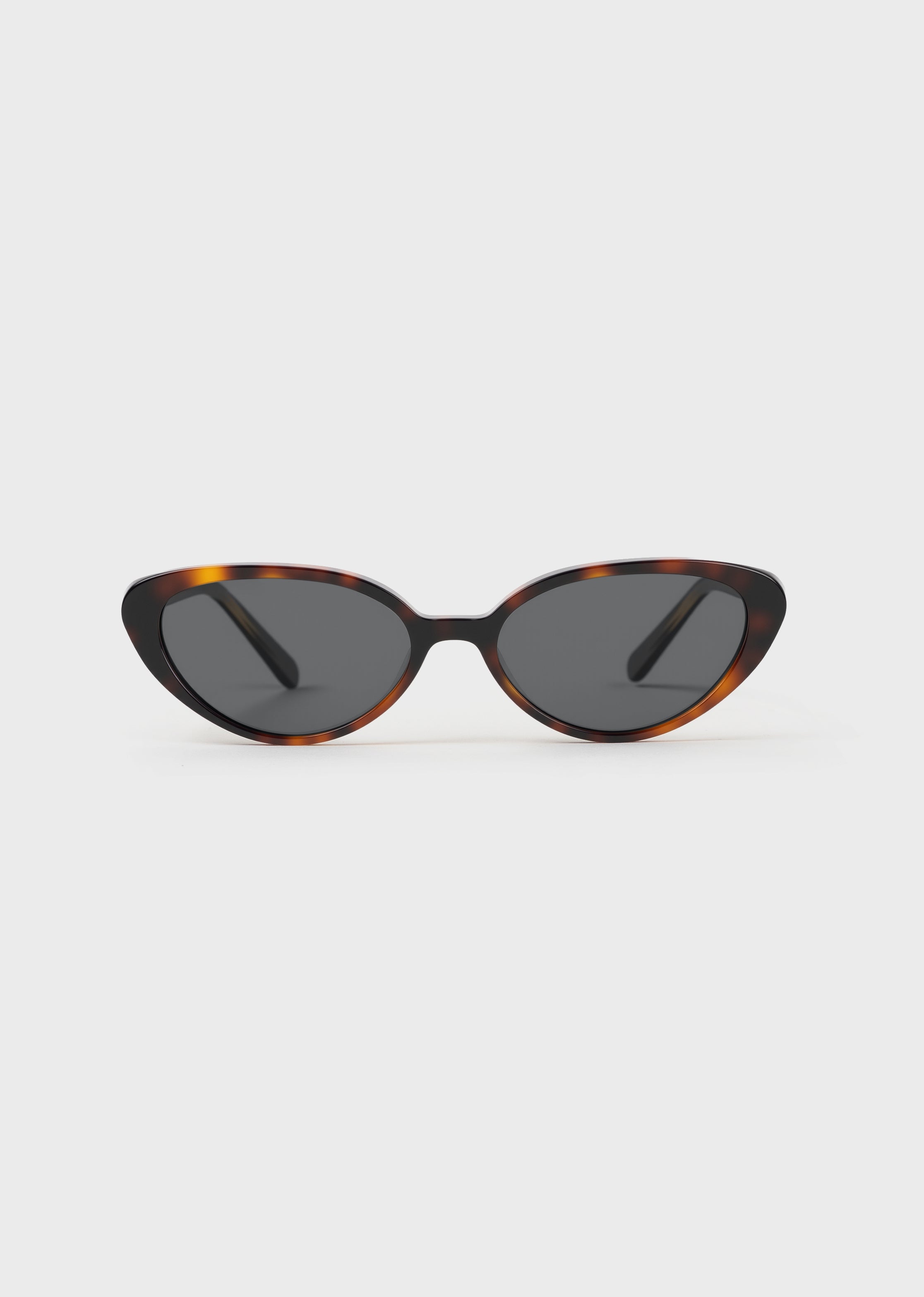 Cat-eye sunglasses with tortoise frame and dark lenses on a white background